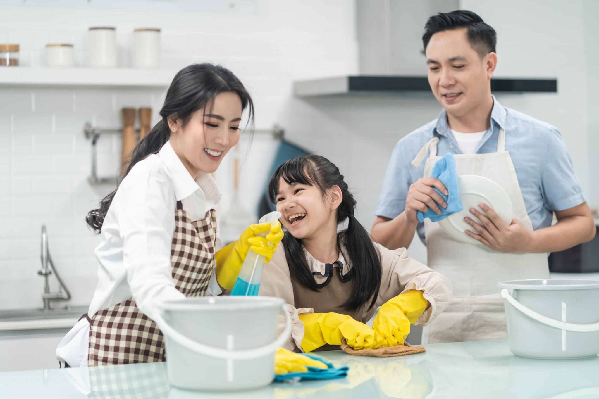 Family cleaning together in a bright modern kitchen